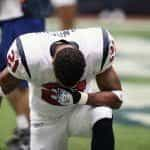 American football player drops to his knees during a game.