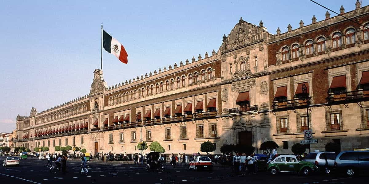 A long view of the Mexico government building, with Mexico’s flag flying in front.