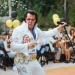 An Elvis impersonator performs at a backyard party.