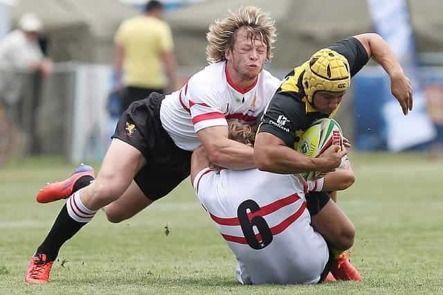 Two rugby players diving for the line in a tackle.