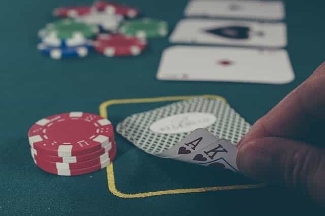 A person looking at their hole cards in a poker game.