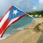 The Puerto Rican flag waves above a beach.