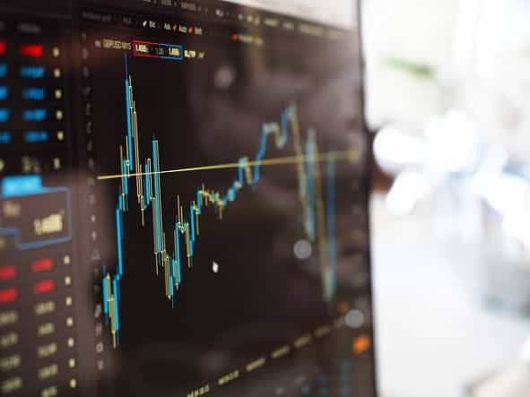 A monitor displaying a chart of a stock on a financial market.