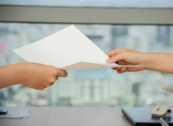 A person handing a document to another person.