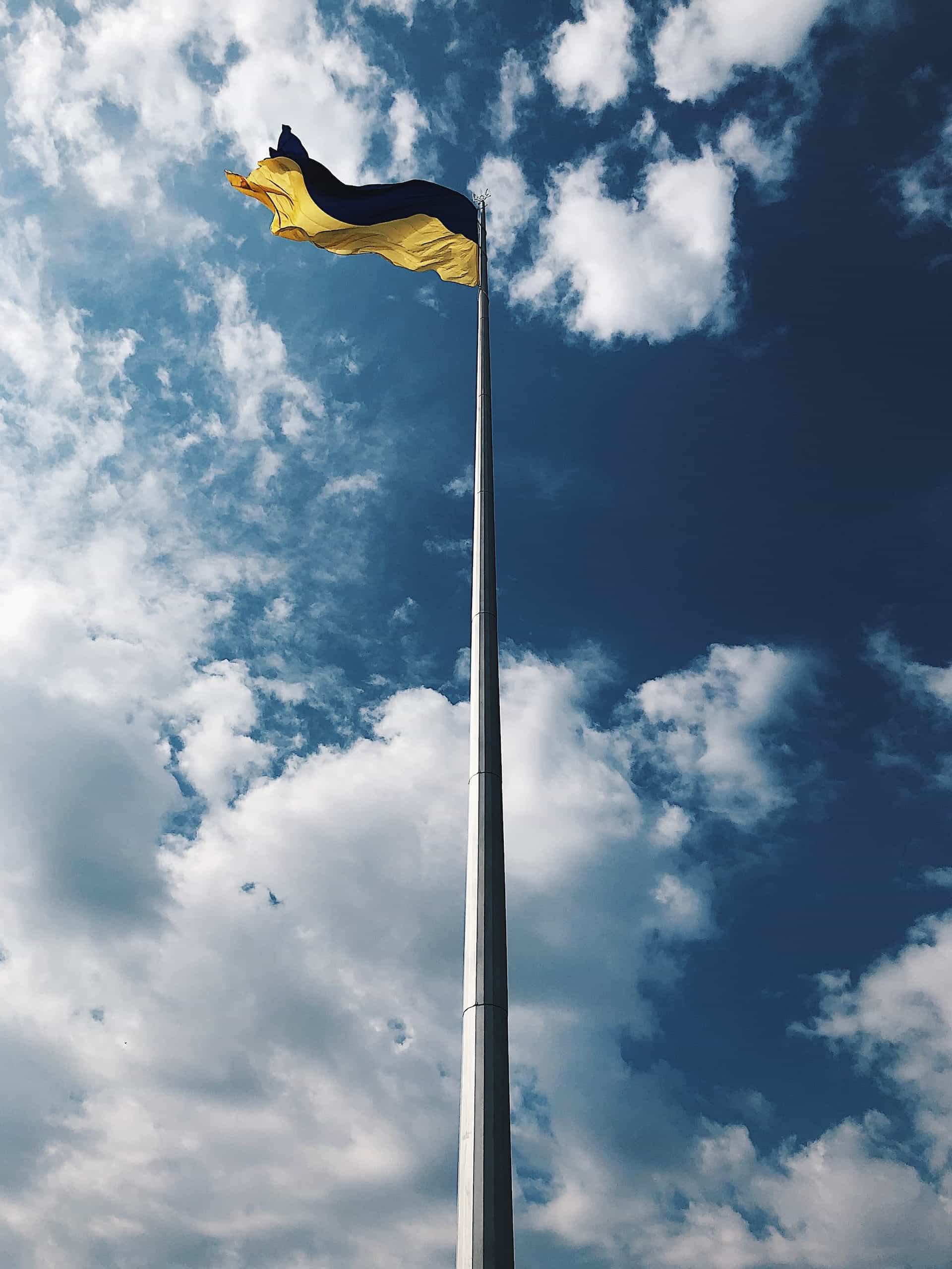 Flag of Ukraine flying against a blue sky.