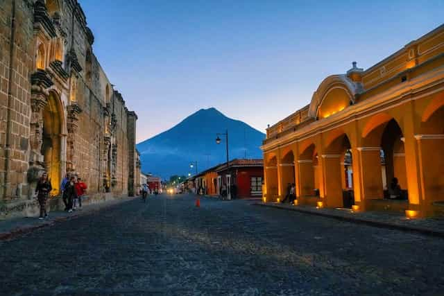 Old fashioned buildings with a mountain in the background in Bulevar Villa Deportiva, Guatemala.