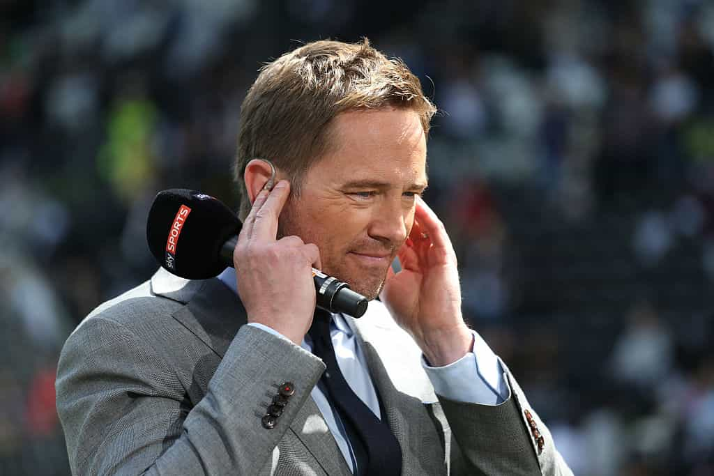 Presenter Simon Thomas holding a Sky Sport microphone.