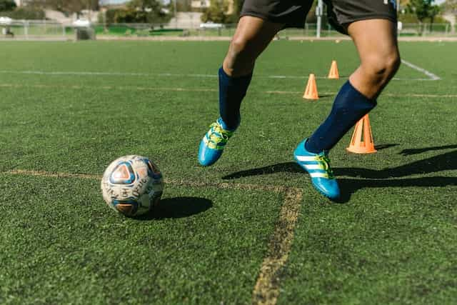 A footballer training on a grass pitch.