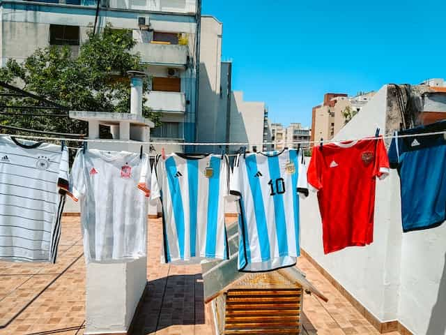 Various soccer jerseys from national teams hang on a washing line.